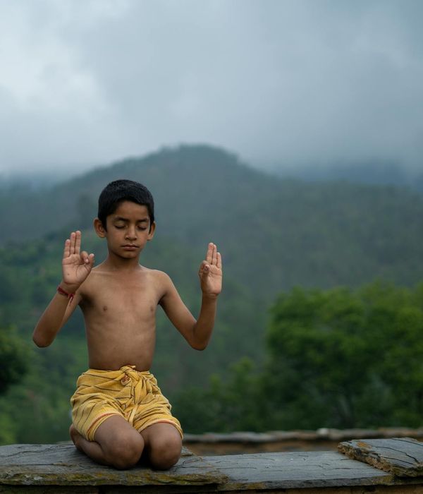 Woman in a calm meditative pose against a khaki background.